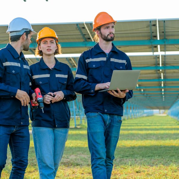 Workers installing solar panels, Engineer team at solar panel farm